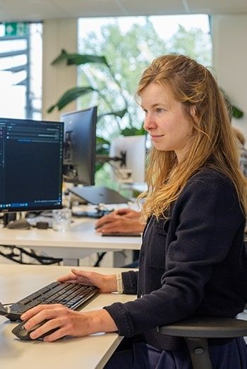 Vrouw programmeert PIM-koppeling op dubbel computerscherm